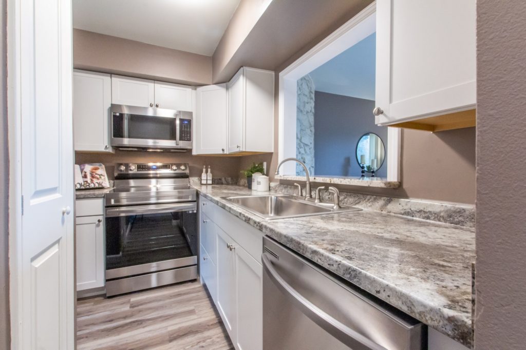 Kitchen in Clarkston apartment. Stainless steel, white cabinets. Bright. 